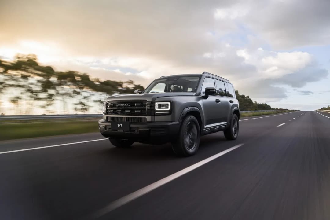 All new GWM Haval H7 in dark grey front three-quarter driving on a highway