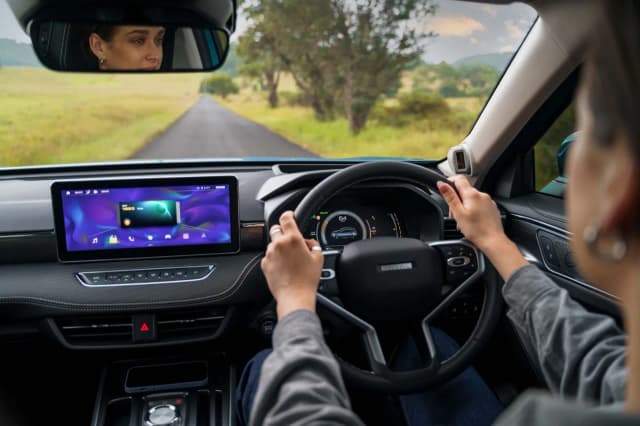 GWM Haval Jolion dashboard and touchscreen from the back seat with driver at the wheel