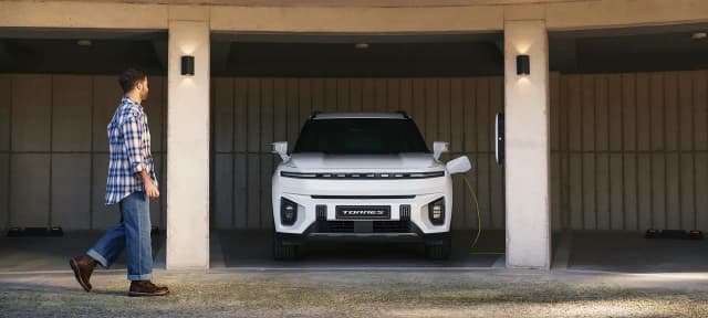 KGM Torres EVX in white charging in a garage