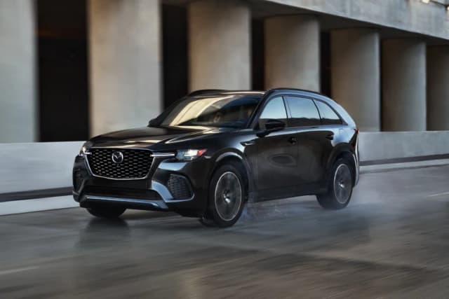 Mazda CX-70 in black driving through an underpass, front three-quarter view