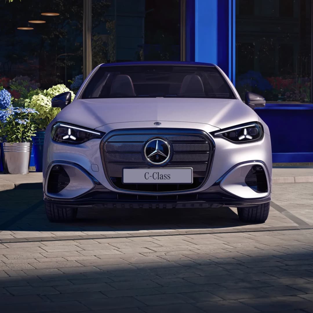 Mercedes-Benz C-Class electric sedan in silver, front view outside a city shopfront