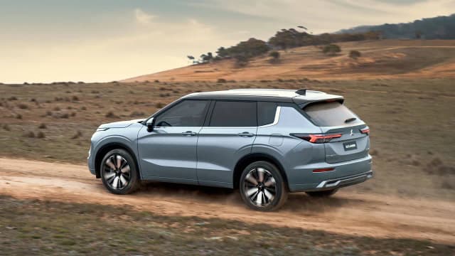 Mitsubishi Outlander rear three-quarter driving on a dirt road