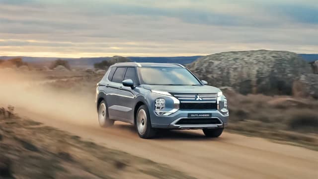 Mitsubishi Outlander driving on a dusty country road
