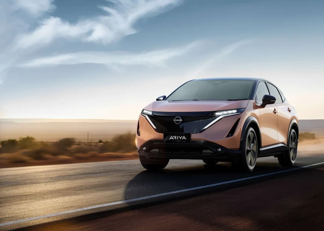 Nissan Ariya front three-quarter driving on a coastal road