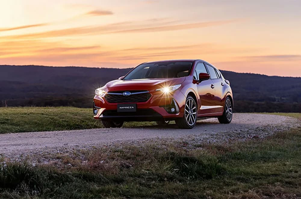 Subaru Impreza 2.0S hatch front three-quarter on a gravel road at sunset