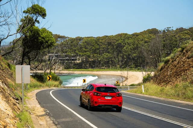 Subaru Impreza hatch driving on a coastal road