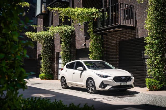 White Subaru Impreza hatch parked outside a terrace house