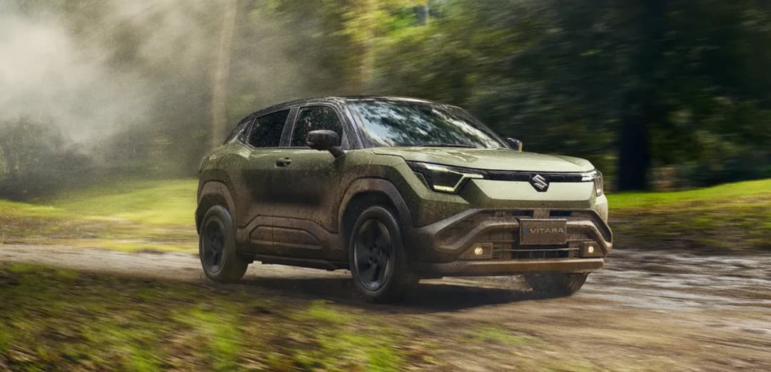 Suzuki e Vitara front three-quarter driving on a forest track
