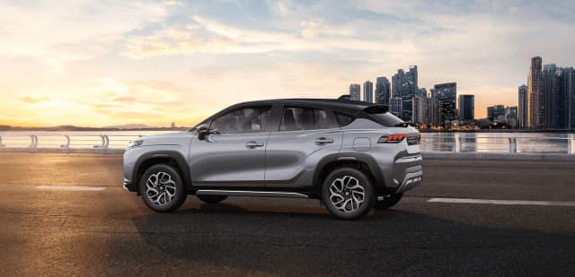Suzuki Fronx Hybrid side view with a city skyline behind