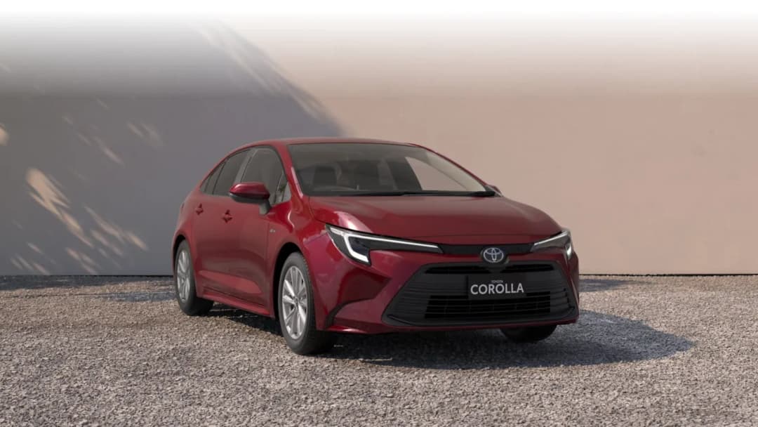 Toyota Corolla sedan hybrid in red, front three-quarter studio view