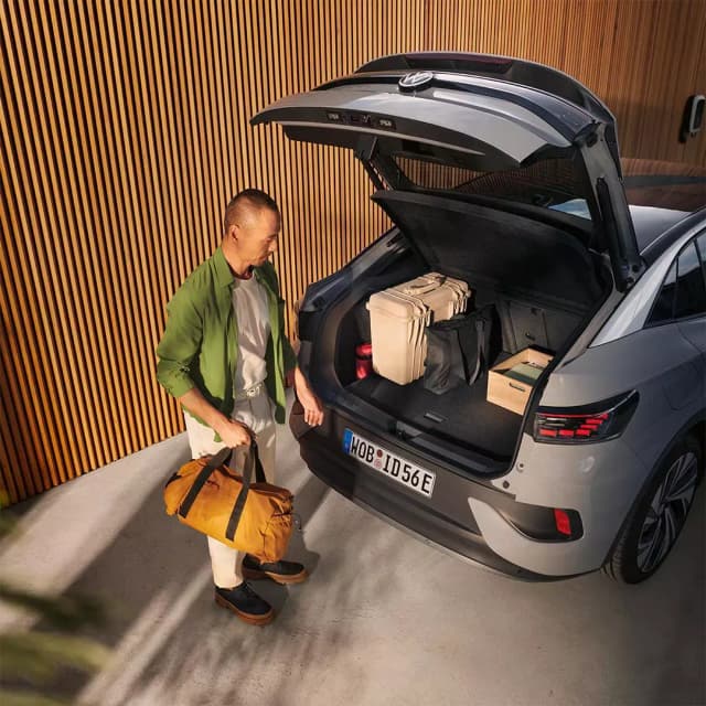 Man loading bags into the open boot of a Volkswagen ID.5