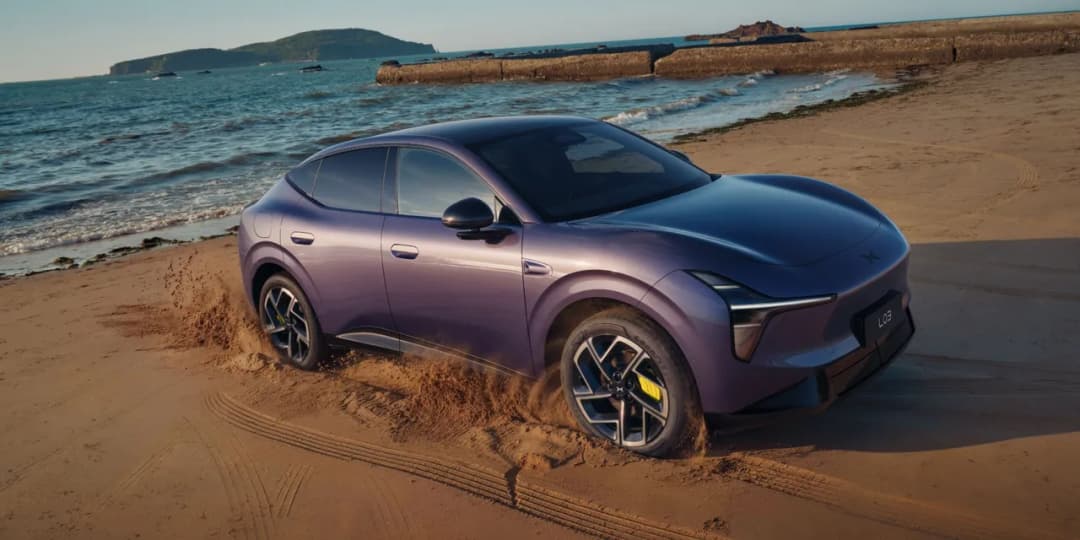 XPeng L03 in Phantom Purple driving on a beach, front three quarter view