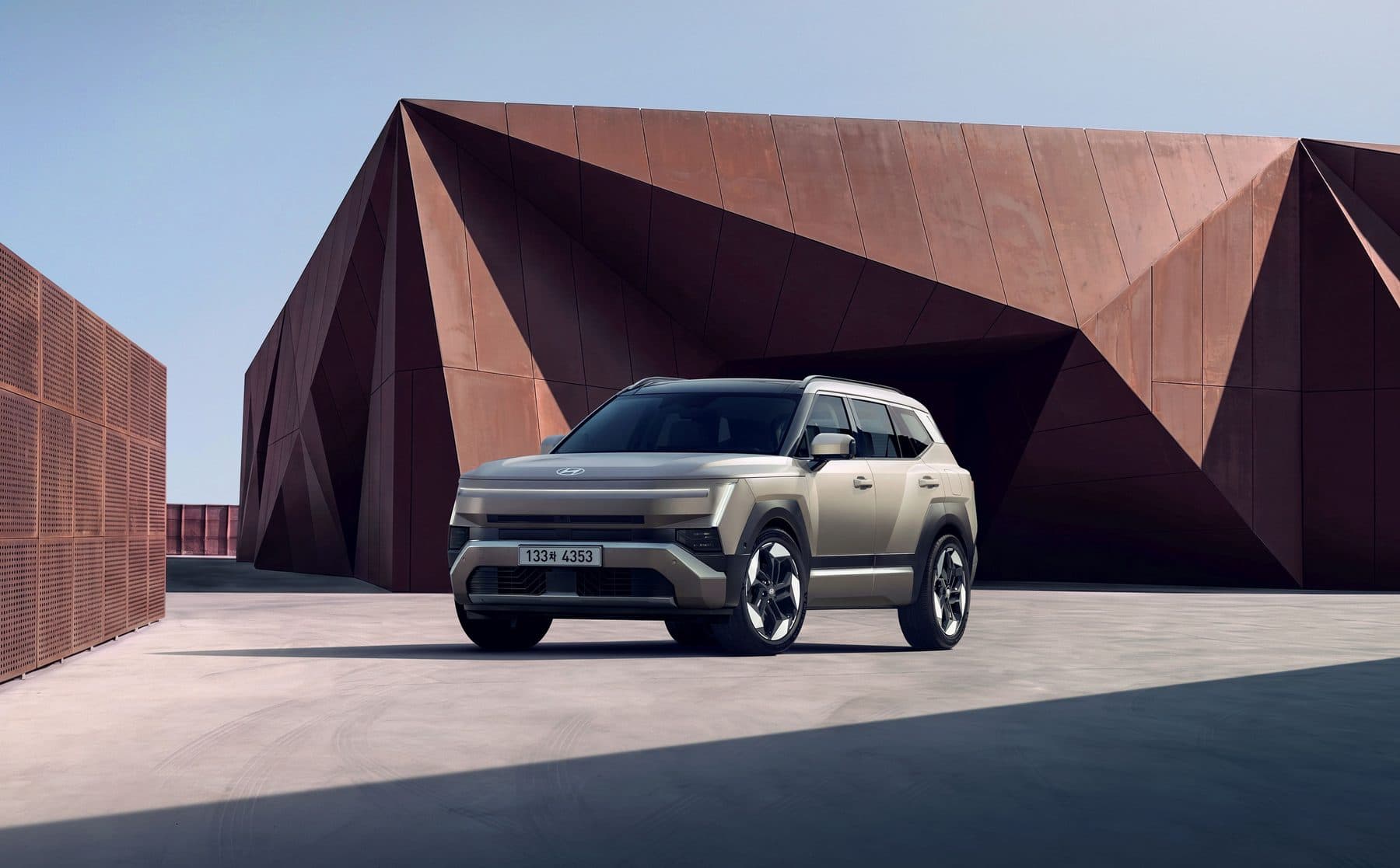 All-new Tucson against a weathered steel building